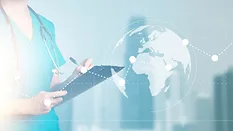 healthcare worker writing on a clipboard with an overlaid image of the globe and a dotted trend line going up