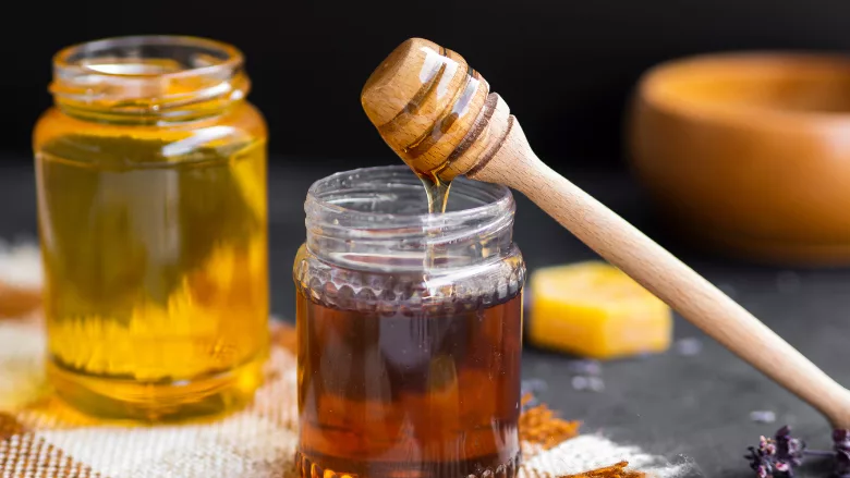 honey in glass jars and dripping honey wand
