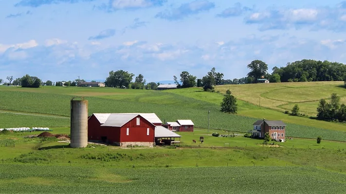 red barn, silo, and farmhouse on farmland in iowa