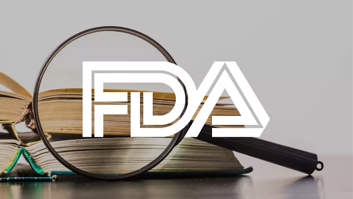 magnifying glass and books with fda logo overlay