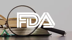 magnifying glass and books with fda logo overlay