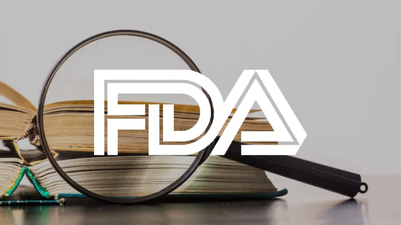 magnifying glass and books with fda logo overlay