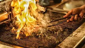 meat engulfed in flame on a grill