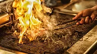 meat engulfed in flame on a grill
