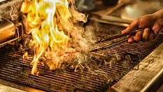 meat engulfed in flame on a grill