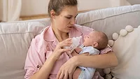 mother giving little baby newborn a bottle