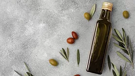 olive oil bottle and olives on gray background