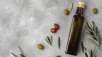 olive oil bottle and olives on gray background