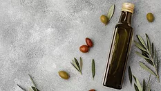 olive oil bottle and olives on gray background