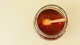 overhead view of a jar of honey with wand in it