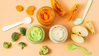 overhead view of jars of baby food, ingredients, and spoons