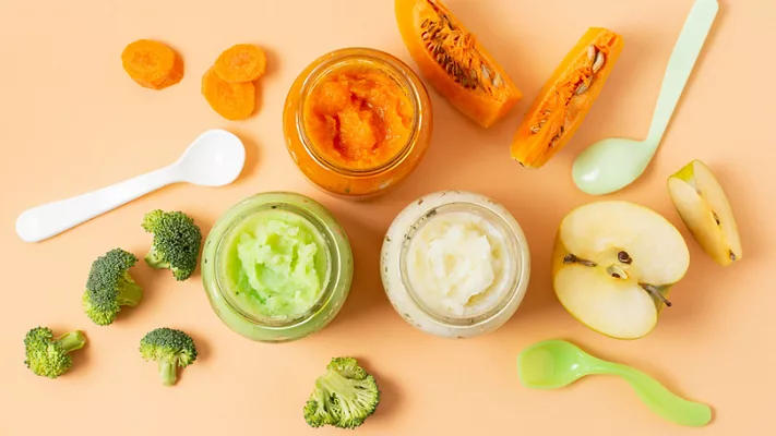 overhead view of jars of baby food, ingredients, and spoons_Freepik via Magnific.png overhead view of jars of baby food, ingredients, and spoons