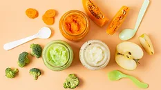overhead view of jars of baby food, ingredients, and spoons