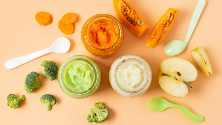 overhead view of jars of baby food, ingredients, and spoons