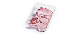 package of raw pork chops on a white background