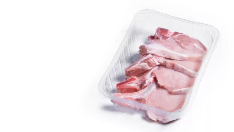 package of raw pork chops on a white background