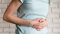 person holding stomach in pain representing GI distress