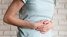 person holding stomach in pain representing GI distress