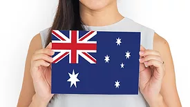 person holding up card with a depiction of the Australian flag