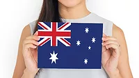 person holding up card with AUS flag_rawpixel via Freepuk.png person holding up card with a depiction of the Australian flag