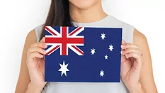person holding up card with a depiction of the Australian flag