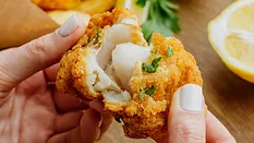 person pulling apart breaded fried white fish_freepik via magnific.png person pulling apart breaded fried white fish