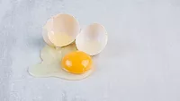 raw egg cracked and runny on table