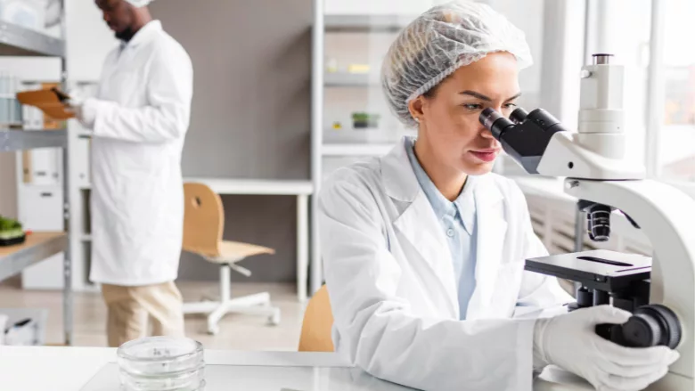 researchers working in a lab using a microscope