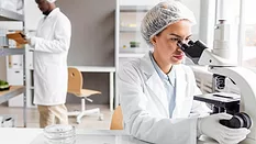 researchers working in a lab using a microscope