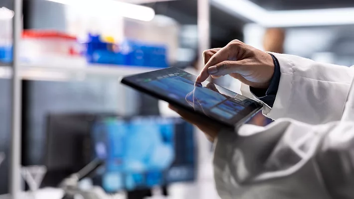 scientist entering data on tablet_DC Studio via Freepik.png scientist entering data on a tablet in a lab