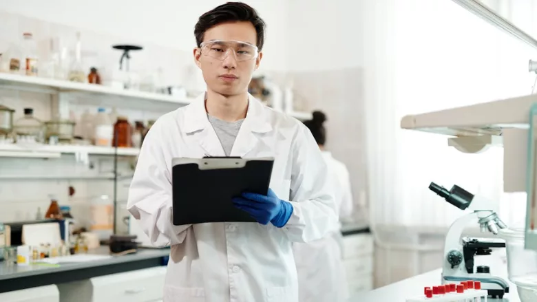 scientist holding clipboard in microbiology lab