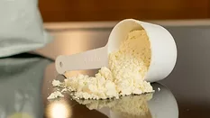 scoop of yellowish white formula milk powder