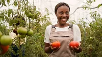 smiling farmer holding tomatoes_Magnific.png smiling farmer holding tomatoes