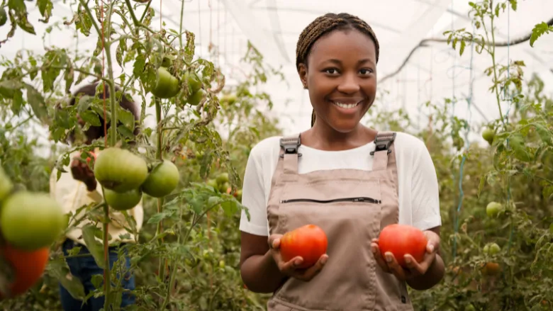 smiling farmer holding tomatoes