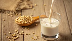 soybeans and a glass of soymilk on a wooden table