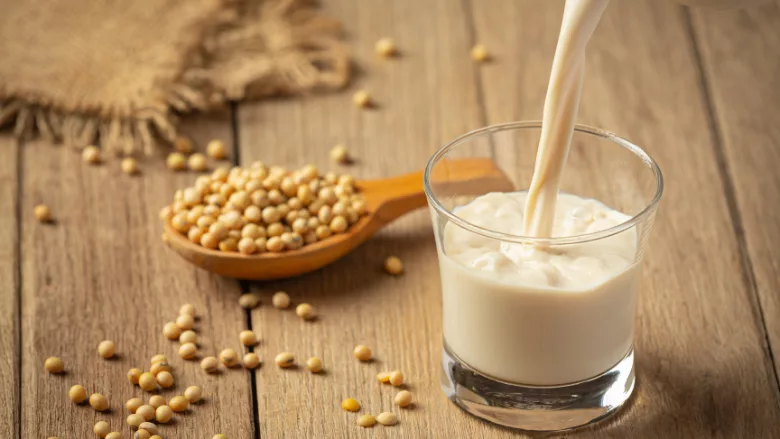 soybeans and a glass of soymilk on a wooden table