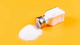 spilled salt shaker against a yellow background