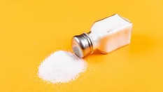 spilled salt shaker against a yellow background
