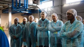 diverse group of people wearing protective clothing in food production plant