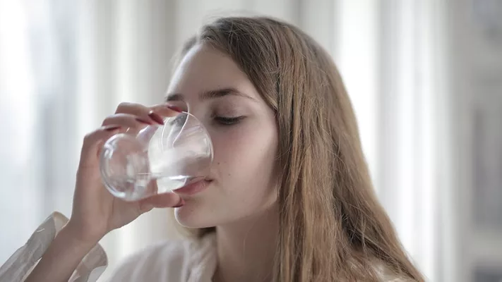woman drinking a glass of water