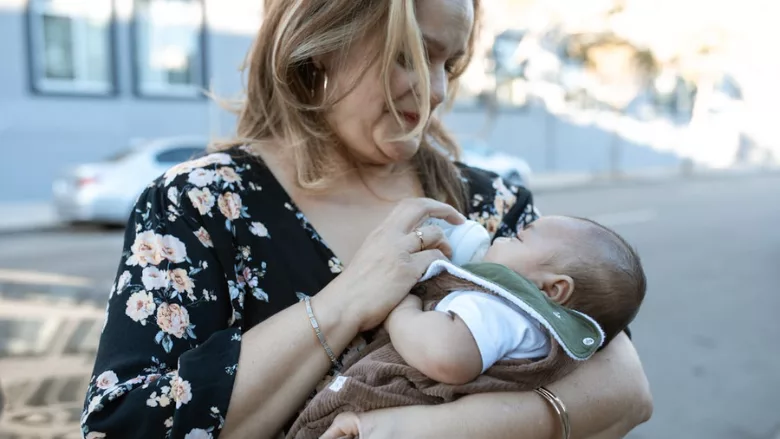 woman feeding baby a bottle