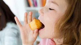 A child eating a mini muffin