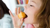 child eating a mini muffin_nensuria via Magnific.png A child eating a mini muffin