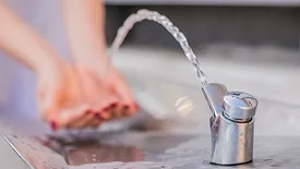 hands catching water from drinking fountain