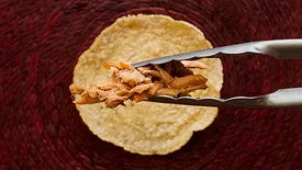 putting pulled pork on a tortilla