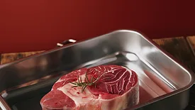 raw steak in stainless steel tray