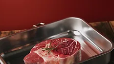 raw steak in stainless steel tray