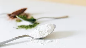 spoonfuls of powdered additives and ingredients in green, white, and brown