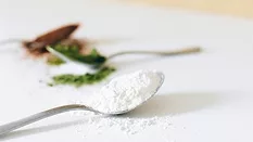 spoonfuls of powdered additives and ingredients in green, white, and brown