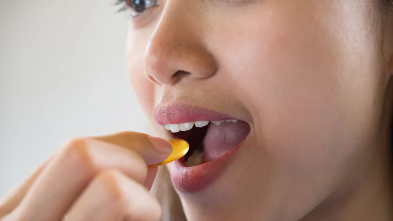 woman taking a vitamin supplement pill